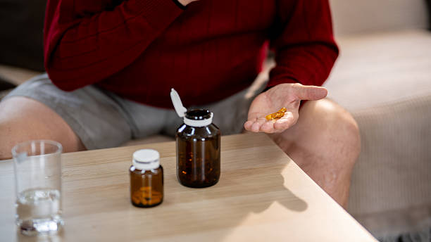 istock An elderly man is sitting and taking medicine in his home. 2218351034