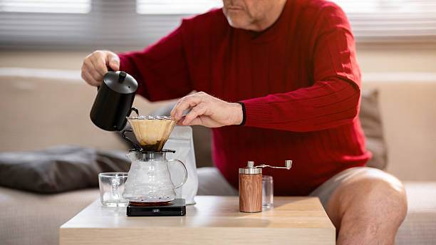 istock An elderly man is happily making coffee on a bright morning at his home. 2218351100