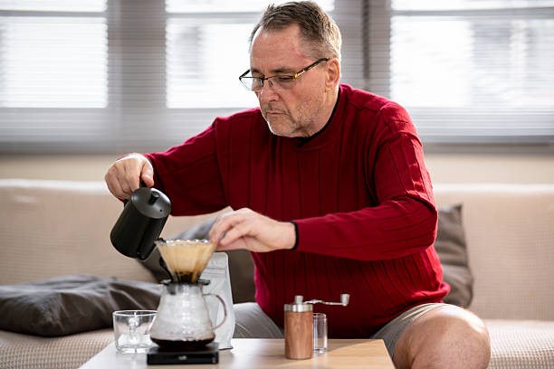 istock An elderly man is happily making coffee on a bright morning at his home. 2218351102