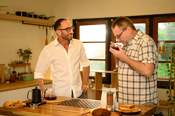 istock Senior man and son enjoy making fresh coffee together. Father day concept 2218351952