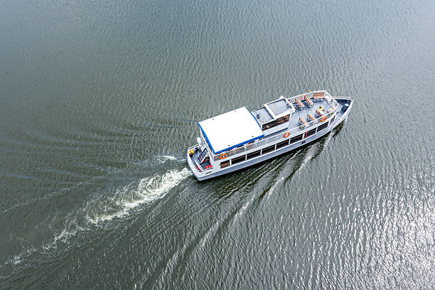 cruising boat moving quickly on the river with a white trace behind. aerial view.