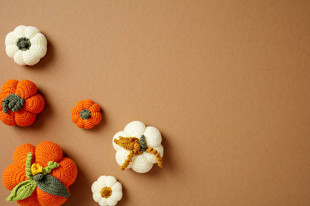 istock Handmade crochet pumpkins on brown background. Autumn, fall concept. 2218362124