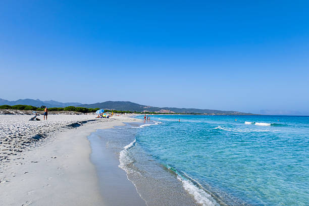 People relaxing at the Cala di Budoni, a very fine light sand beach lapped by crystalline sea in the Gallura