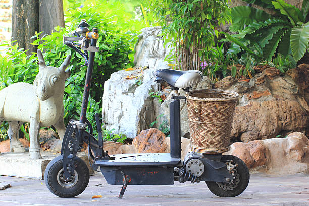 Bolzano, Italy - July 31, 2025: Several scooters parked side by side near sidewalk in city square, featuring Vespa and Piaggio among other popular makes