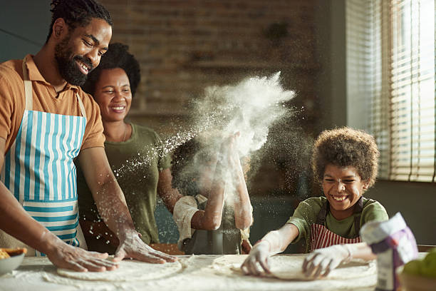 istock Happy black family having fun while making a cake at home. 2218374321