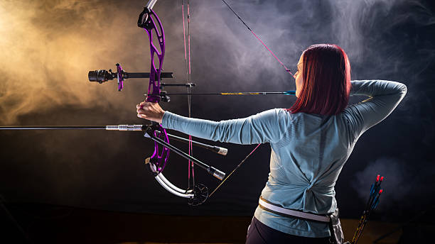 istock Female Archer with Purple Compound Bow in Smoky Studio 2218374489