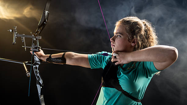 istock Female Archer Drawing Recurve Bow with Intense Focus 2218374546
