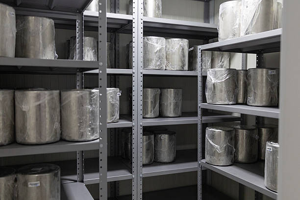 Vertical no people shot of part of pottery workshop interior with potters wheel and earthenware on shelves, copy space