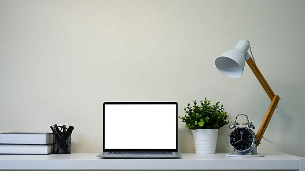 istock Bright home office desk with laptop, coffee mug, notebook, and indoor plants. 2218388026