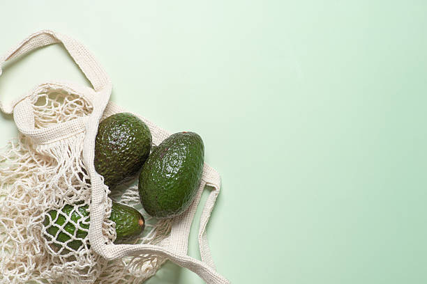 istock Fresh Avocados in a Beautiful Natural Bag on a Green Surface 2218388894