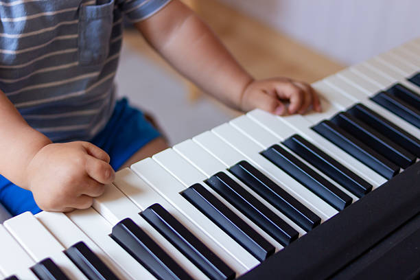 Baby boy learning to play the piano using an educational app