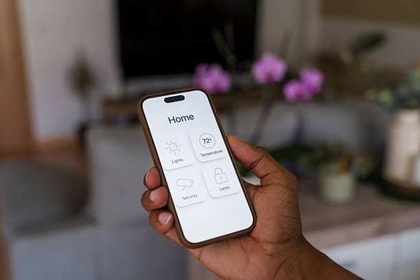 istock Person holding smartphone and managing smart home devices 2218391381