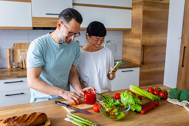 istock Couple Enjoying Cooking Together While Using Smartphone in Kitchen 2218392322