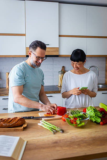 istock Couple Enjoying Cooking Together While Using Smartphone in Kitchen 2218392361