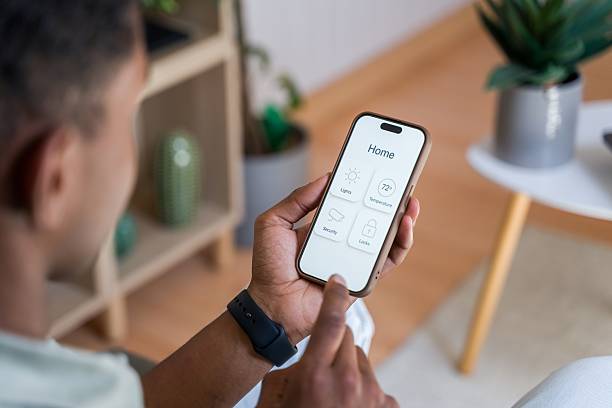 istock Man controlling home automation system with smartphone app 2218392378