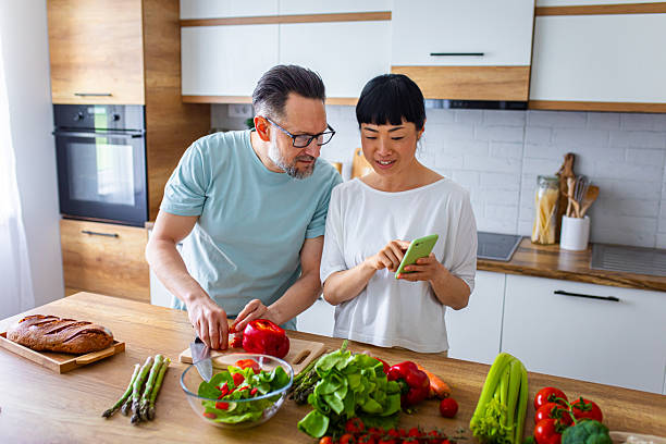 istock Couple Enjoying Cooking Together While Using Smartphone in Kitchen 2218392491