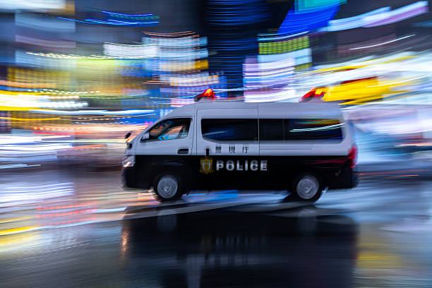 Japanese police van driving through the streets of Tokyo at night in the rain, May 2025