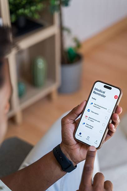 istock Patient using medical reminder app on smartphone at hom 2218393545