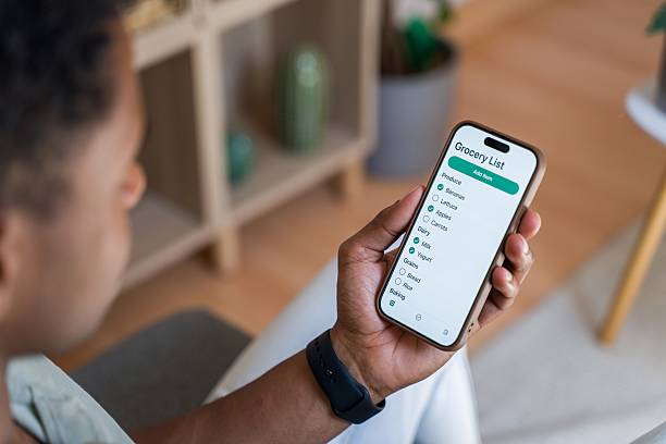 istock Man using grocery list app on smartphone 2218393569