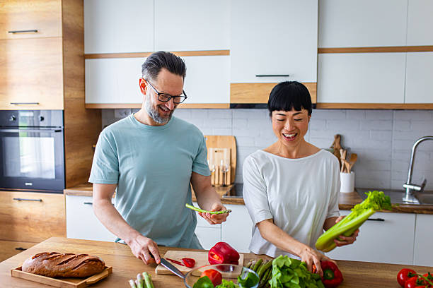 istock Happy Partners Preparing Salad in Modern Kitchen 2218393953
