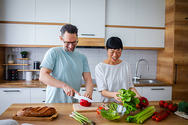 istock Happy Partners Preparing Salad in Modern Kitchen 2218394025