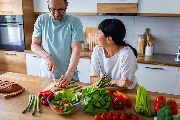 istock Happy Partners Preparing Salad in Modern Kitchen 2218394098
