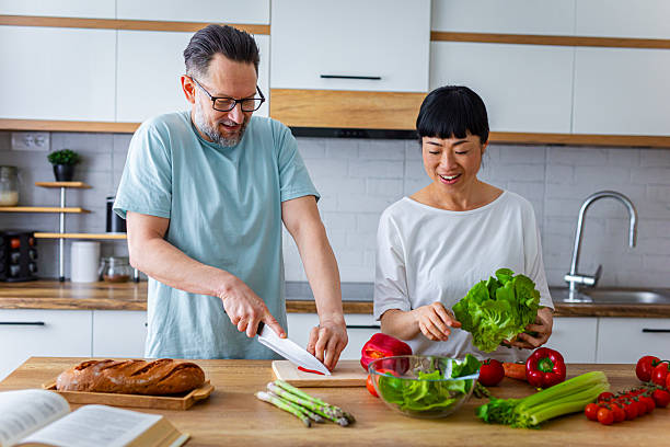istock Happy Partners Preparing Salad in Modern Kitchen 2218394166