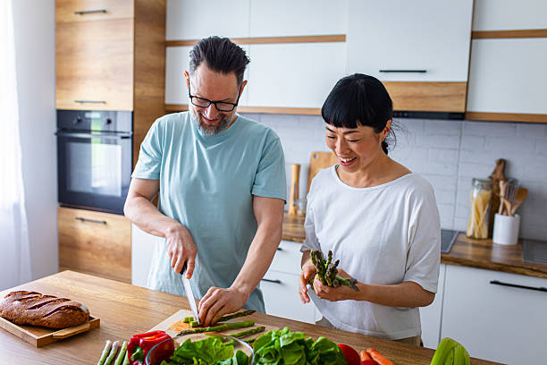 istock Happy Partners Preparing Salad in Modern Kitchen 2218394197