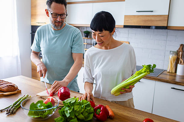 istock Happy Partners Preparing Salad in Modern Kitchen 2218394246