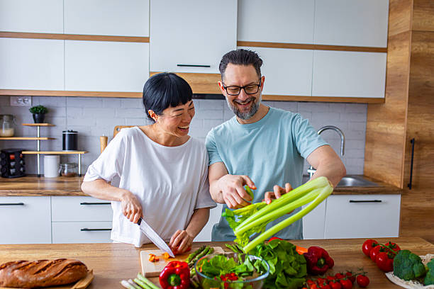istock Happy Partners Preparing Salad in Modern Kitchen 2218394279