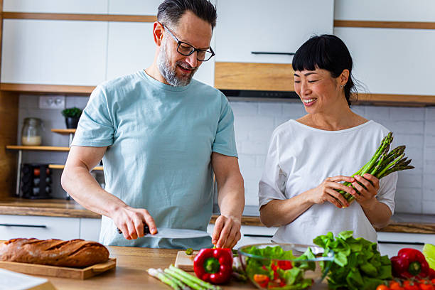 istock Smiling Couple Preparing Healthy Meal Together in Kitchen 2218394313