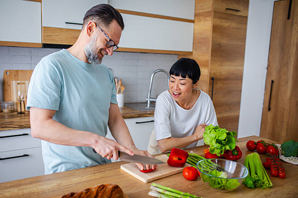 istock Smiling Couple Preparing Healthy Meal Together in Kitchen 2218394455