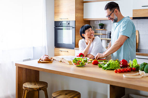 istock Smiling Couple Preparing Healthy Meal Together in Kitchen 2218394468