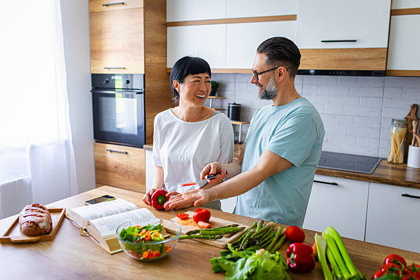 istock Smiling Couple Preparing Healthy Meal Together in Kitchen 2218394542