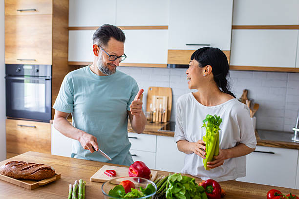 istock Smiling Couple Preparing Healthy Meal Together in Kitchen 2218394552