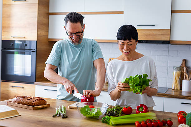 istock Smiling Couple Preparing Healthy Meal Together in Kitchen 2218394662