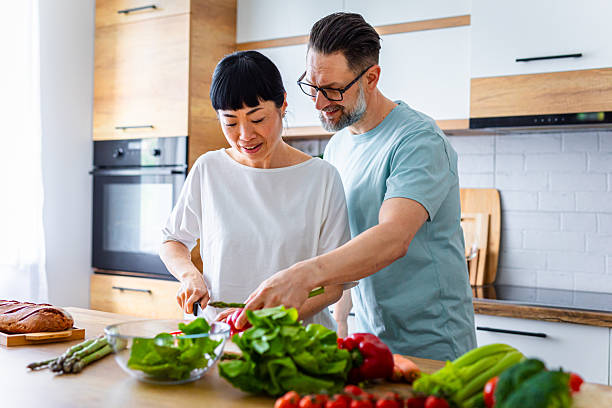 istock Smiling Couple Preparing Healthy Meal Together in Kitchen 2218394709