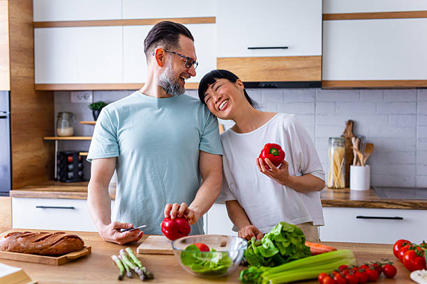 istock Smiling Couple Preparing Healthy Meal Together in Kitchen 2218394776