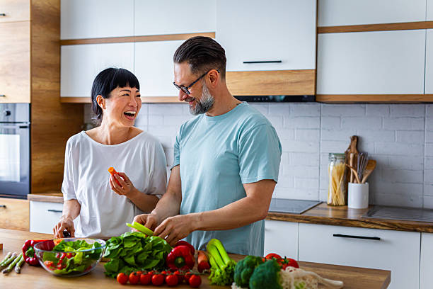 istock Smiling Couple Preparing Healthy Meal Together in Kitchen 2218394827