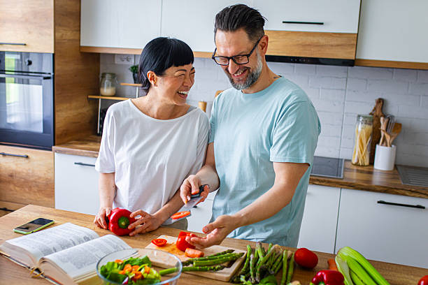 istock Smiling Couple Preparing Healthy Meal Together in Kitchen 2218394838