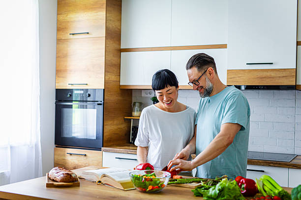 istock Smiling Couple Preparing Healthy Meal Together in Kitchen 2218394876