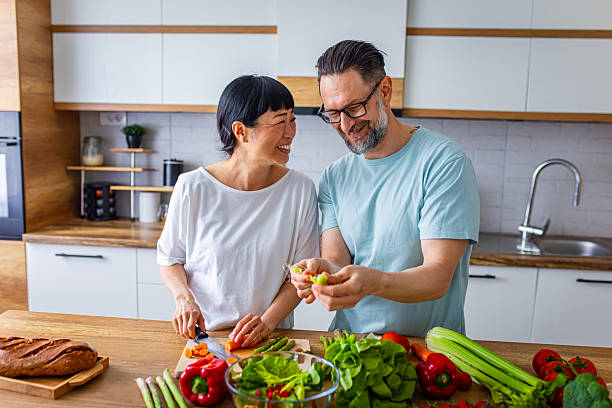 istock Smiling Couple Preparing Healthy Meal Together in Kitchen 2218394895