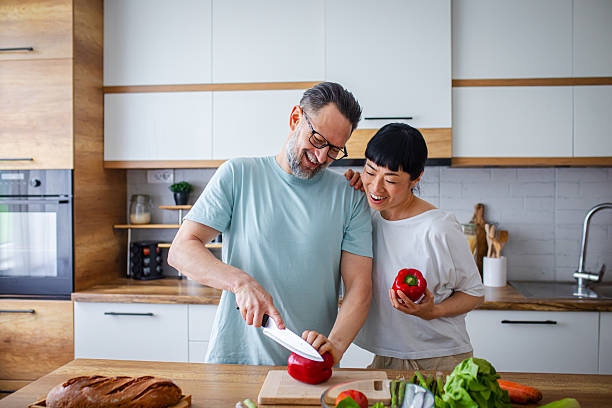 istock Smiling Couple Preparing Healthy Meal Together in Kitchen 2218394911