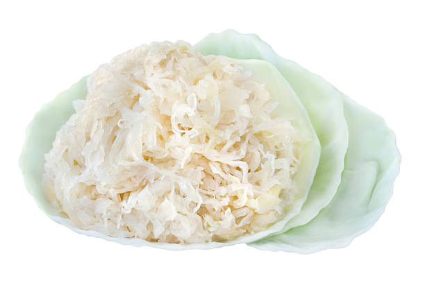 Sauerkraut and cabbage leaves isolated on white background