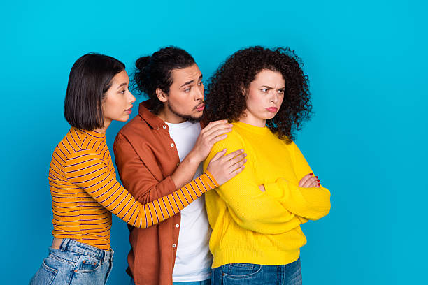 istock Young friends showcasing emotional dynamics and gestures on vibrant blue background portraying conflict and reconciliation 2218395599