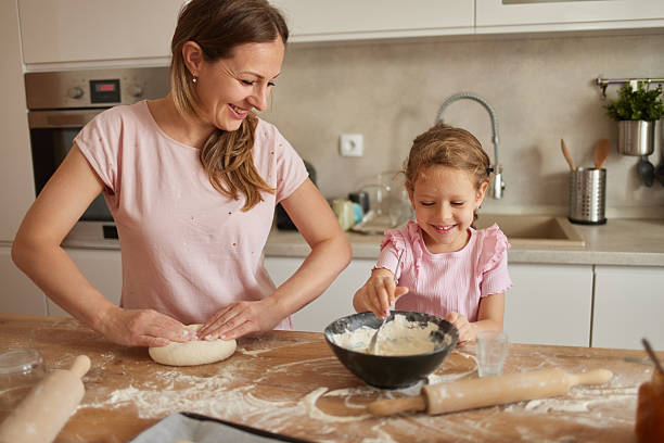 istock Mother and daughter making dough in the kitchen 2218401149
