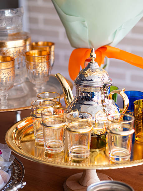Traditional tea service featuring ornate teapot and colorful glasses during afternoon gathering