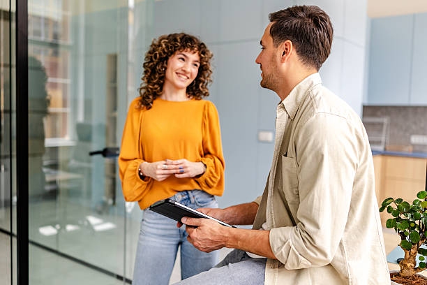 istock Colleagues engage in a friendly discussion in a modern office setting while enjoying their workday and utilizing technology 2218402993