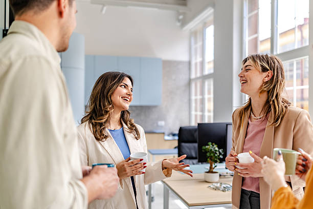 istock Colleagues engage in a lively conversation while enjoying coffee in a modern office environment 2218403263