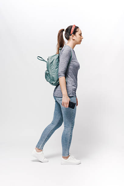 istock Young woman with a backpack on her shoulders walking. 2218403692